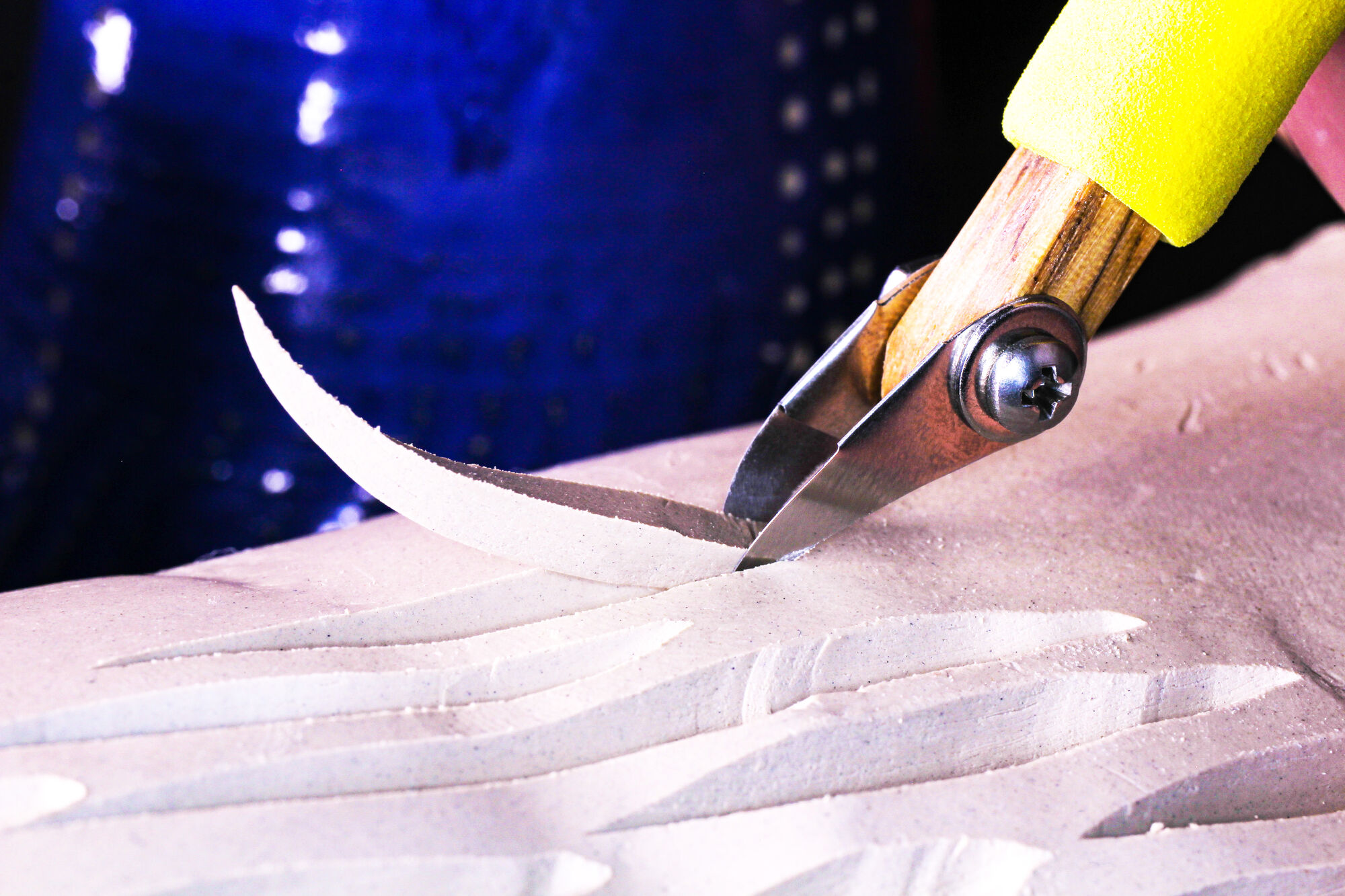 Close up of the P1 Curved V Tip Carving Tool carving into clay.