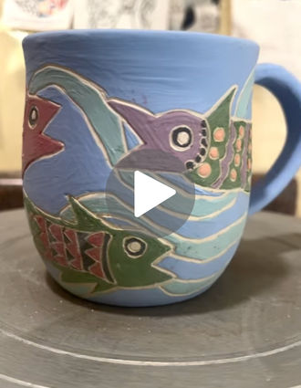 Colorful ocean-inspired mug featuring carved fish and waves, highlighted with bright underglaze using DiamondCore® carving tools.