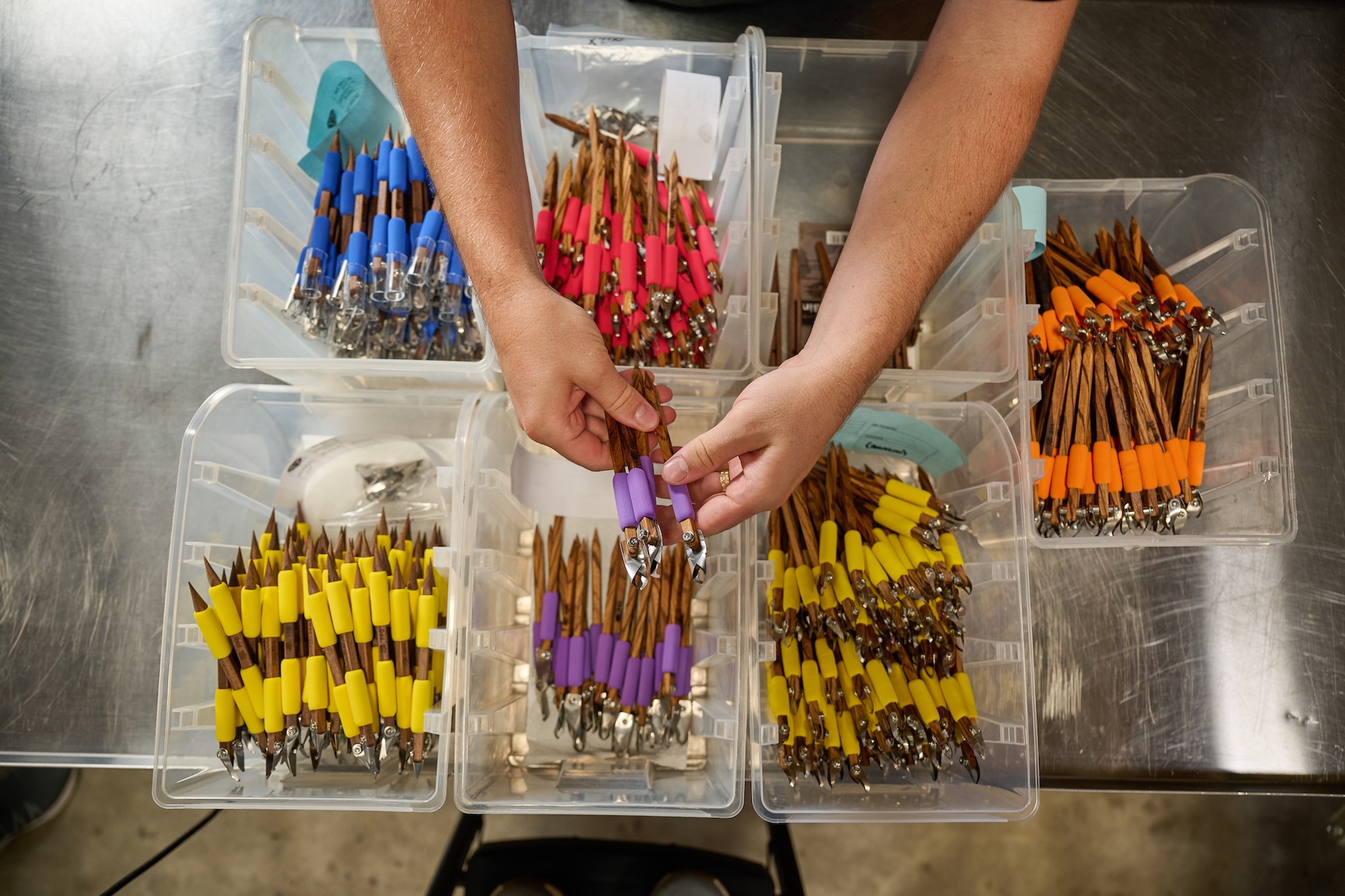 A DCT employee sorting colorful tools into boxes.